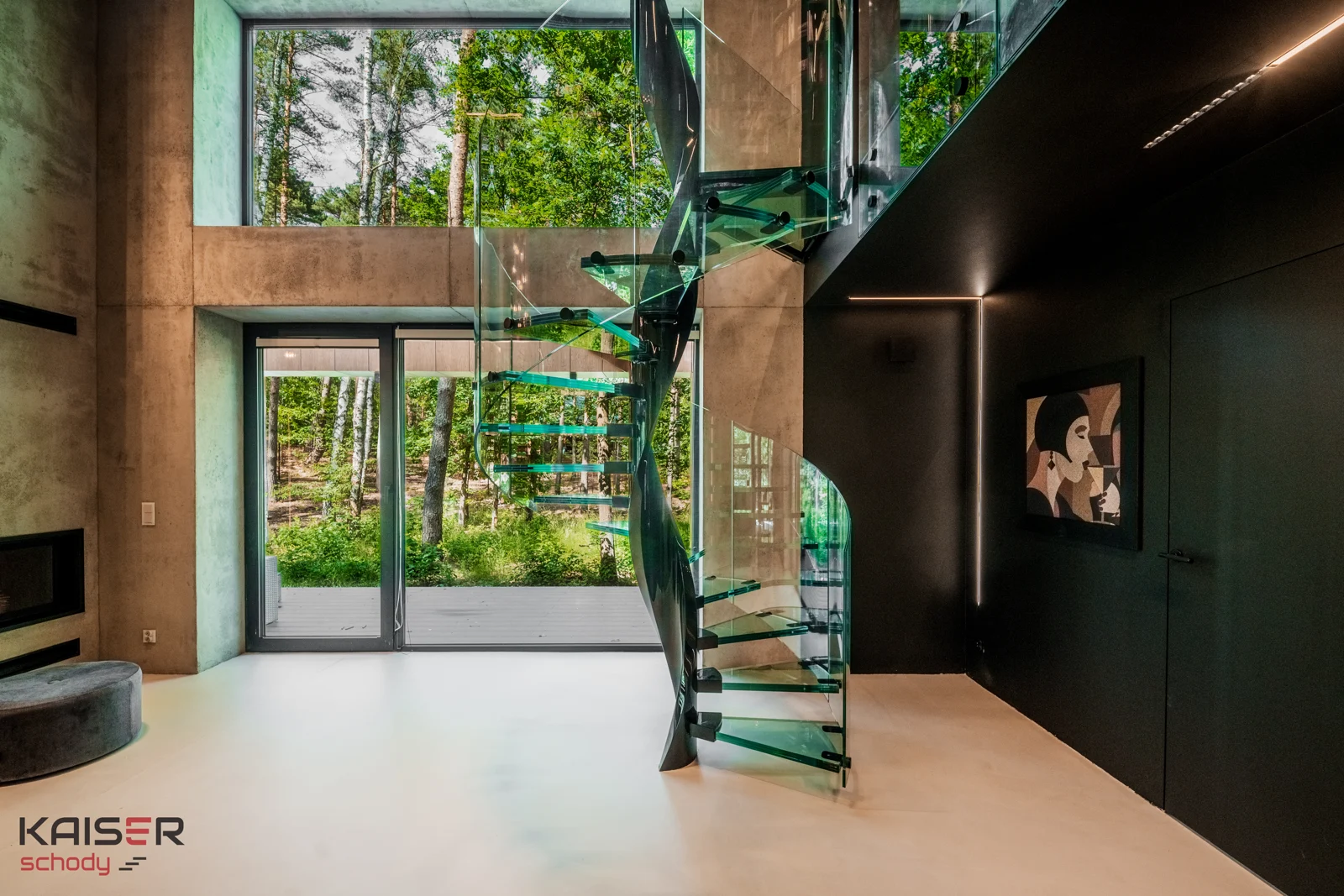 Wendeltreppe mit Glasstufen neben großen Fenstern und einer Bibliothek